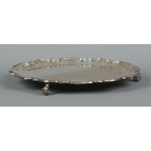 95 - A George VI silver salver with scalloped edge and raised on three scrolled feet. Assayed Sheffield 1... 