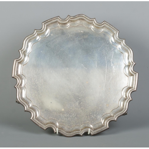 95 - A George VI silver salver with scalloped edge and raised on three scrolled feet. Assayed Sheffield 1... 