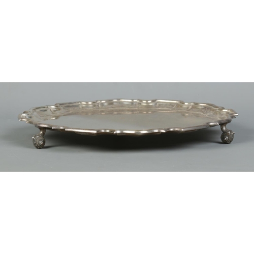 95 - A George VI silver salver with scalloped edge and raised on three scrolled feet. Assayed Sheffield 1... 