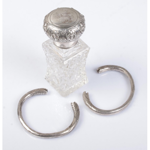 556 - An Indian silver topper jar along with a pair of Eastern white metal snake head bangles/armlets.