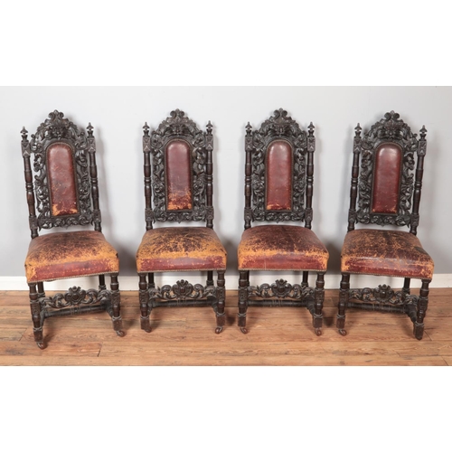 565 - A set of four oak green man chairs with red leather upholstery and on castors