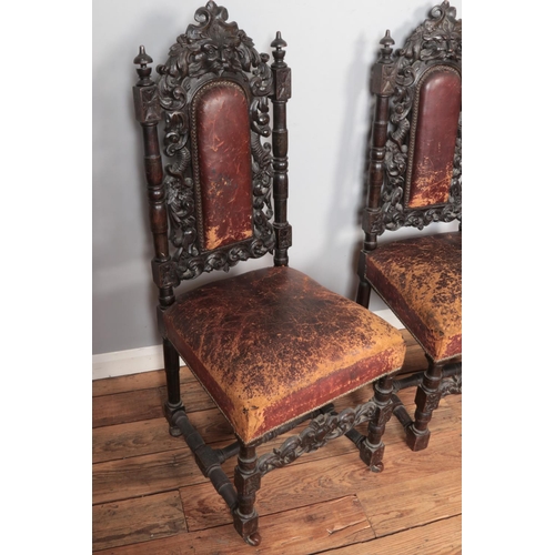 565 - A set of four oak green man chairs with red leather upholstery and on castors