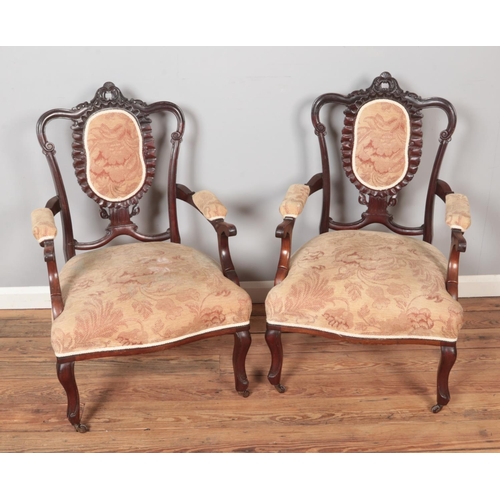 566 - A pair of carved open arm salon chairs.