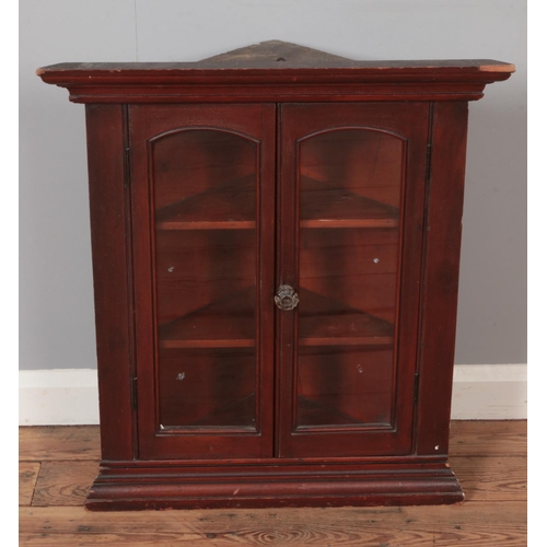 567 - A pine corner cupboard of small proportions with glazed double doors.

Hx71cm
Wx64cm