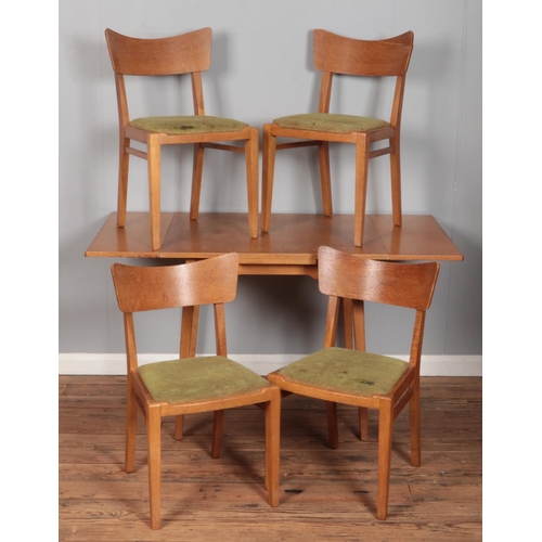 571 - A light oak drawer leaf dining table with four matching chairs.