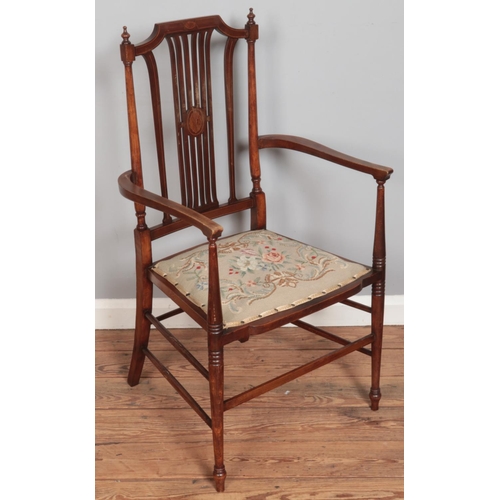 574 - An Edwardian inlaid mahogany salon chair with floral upholstered seat.