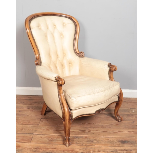 576 - A carved walnut spoon back chair with cream leather upholstery.