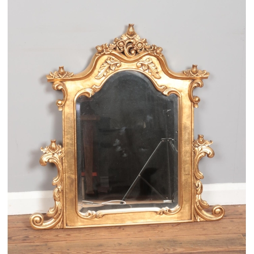 481 - An ornate gilt framed bevel edged mirror featuring scroll decoration. Approx. dimensions 82cm x 81cm... 