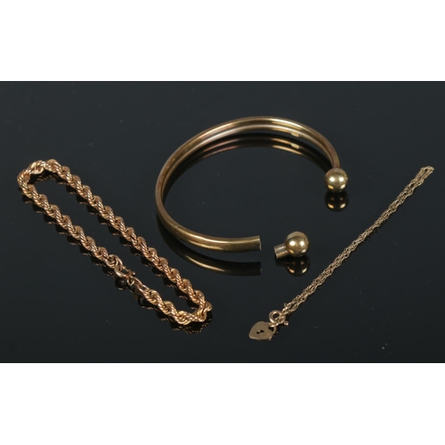 497 - Three pieces of 9ct gold jewellery. Includes rope twist bracelet, trace bracelet with heart shaped l... 