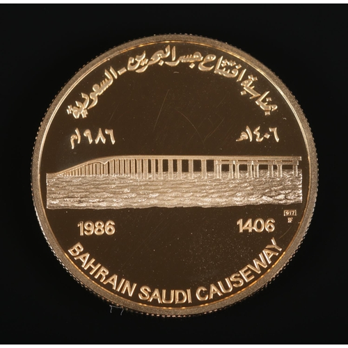 514 - 1986 Bahrain Saudi Causeway gold coin in original display case and sleeve. 31.18g.