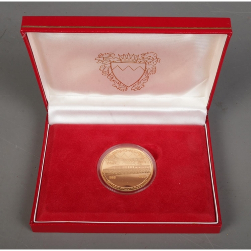 514 - 1986 Bahrain Saudi Causeway gold coin in original display case and sleeve. 31.18g.