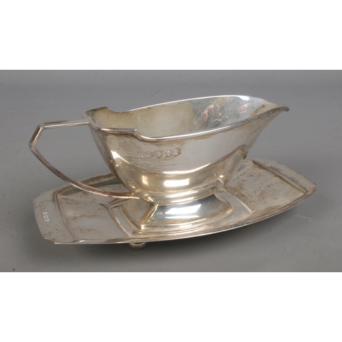 536 - A silver sauceboat with matching stand raised on foot ball feet. Assayed Birmingham 1938 by Davies &... 