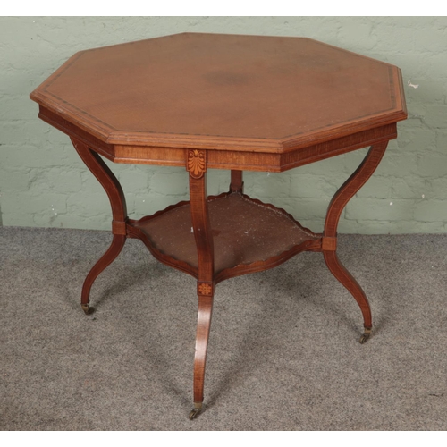 596 - A large Edwardian mahogany inlaid table with shaped legs united by a lower tier shelf on brass casto... 