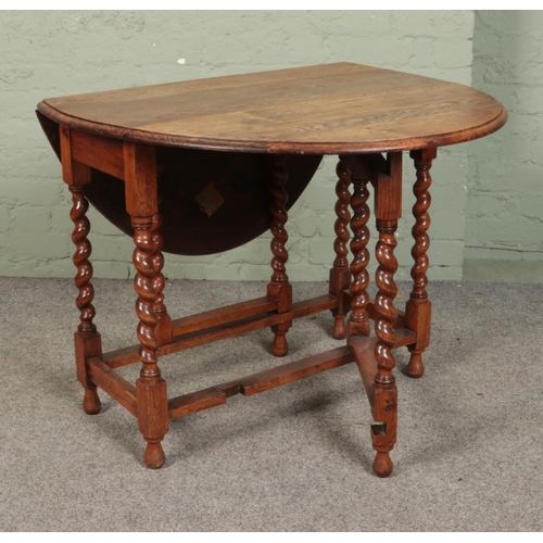 603 - An oak gate leg table with barley twist supports.