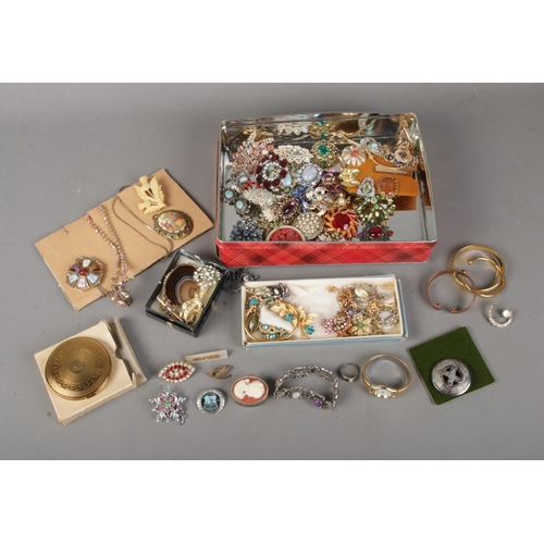 148 - A tin of assorted costume jewellery to include good collection of vintage brooches, necklaces, bangl... 