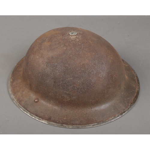 163 - A British World War Two Brodie helmet with chin strap.