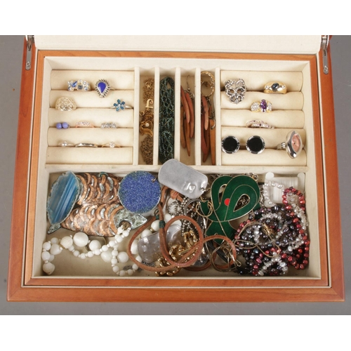 179 - A wooden jewellery box with contents of costume jewellery. Includes rings, enamel pendants etc.