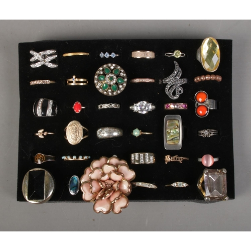 181 - A collection of 36 costume jewellery dress rings to include floral, baby and bird examples.