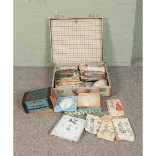 270 - A suitcase with contents of vintage sewing patterns, Airlyne rugmaker, linens, etc.