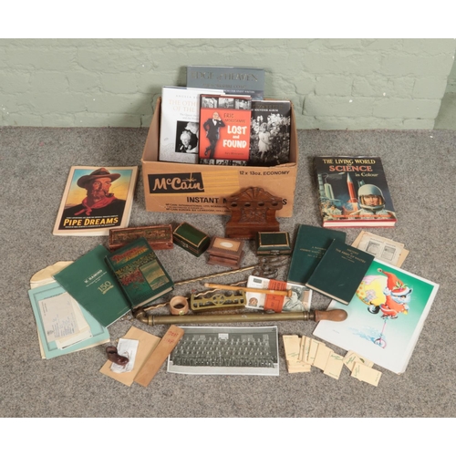 312 - A box of miscellaneous. Includes John Duggan watercolour, carved oak pipe rack, books, garden spraye... 