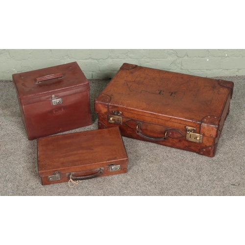 317 - Three vintage leather suitcases of varying sizes with two monogramed to fronts.