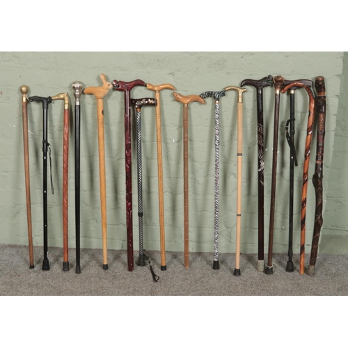 356 - A collection of walking sticks. Includes carved examples with dragon, white metal and abalone, brass... 