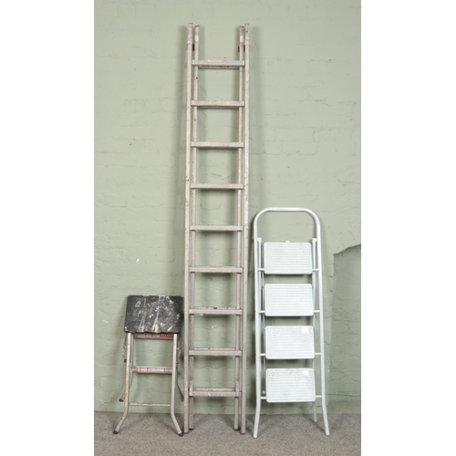 374 - A tall adjustable ladder (250cm) along with two smaller step ladders.