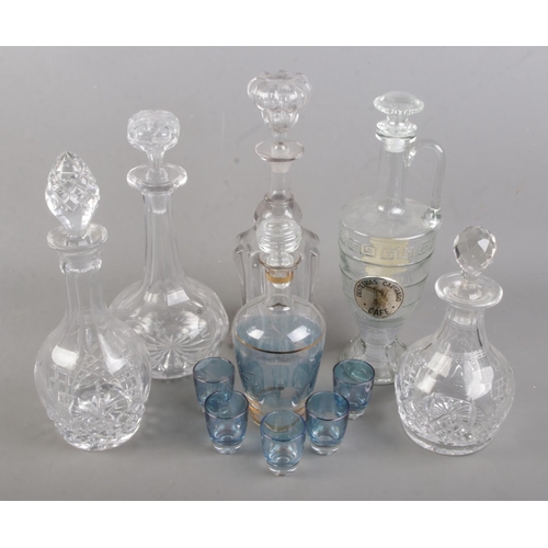 62 - A collection of glass decanters. Includes French coloured and etched glass liquor set.