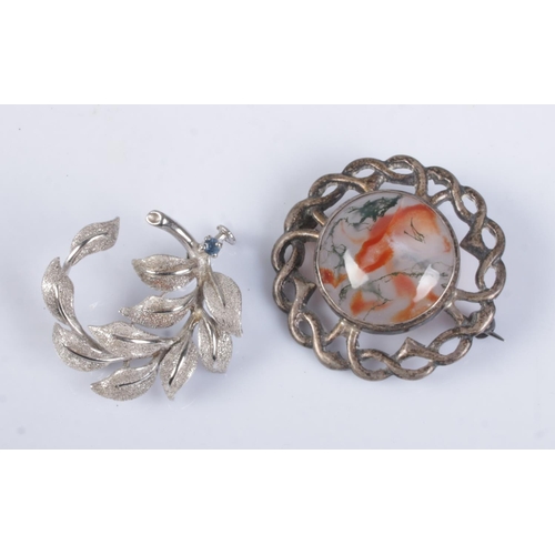 481 - Two silver brooches. Includes moss agate example and floral spray with sapphire coloured stone.