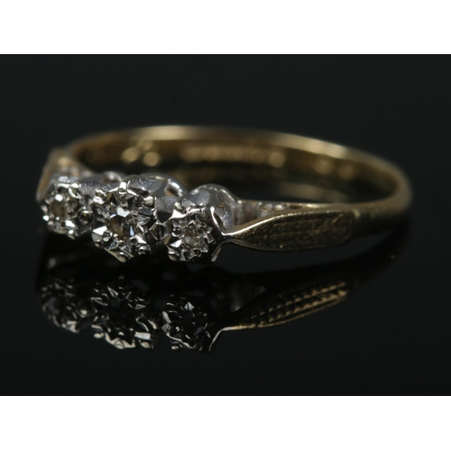 484 - An 18ct gold three stone diamond ring in illusion setting. Size K. 1.6g.