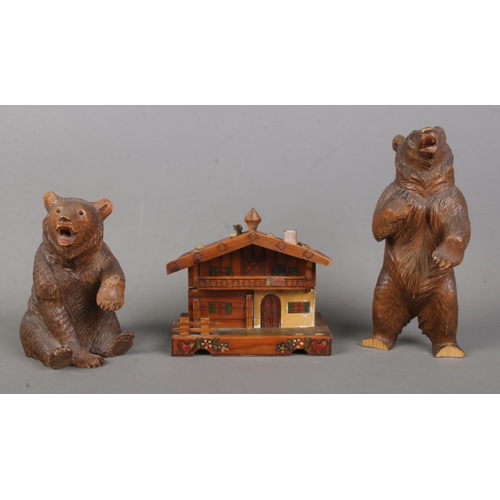 79 - Two Black Forest style carved wooden bears together with a similar style music box, formed as a hous... 