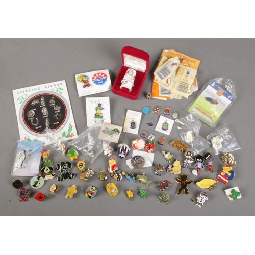 526 - A box of collectables. Includes Sterling Silver Charms sheet, silver and enamel charms, pin badges, ... 