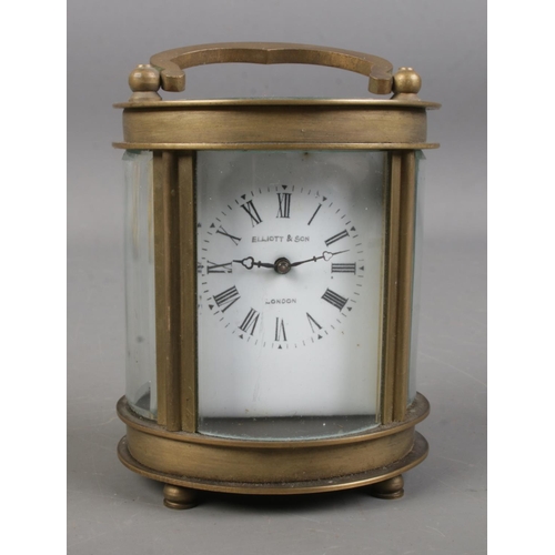 543 - An Elliot and Son brass and glass carriage clock in oval form.