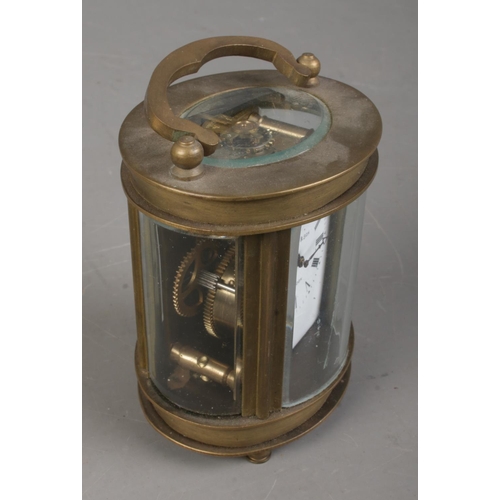 543 - An Elliot and Son brass and glass carriage clock in oval form.