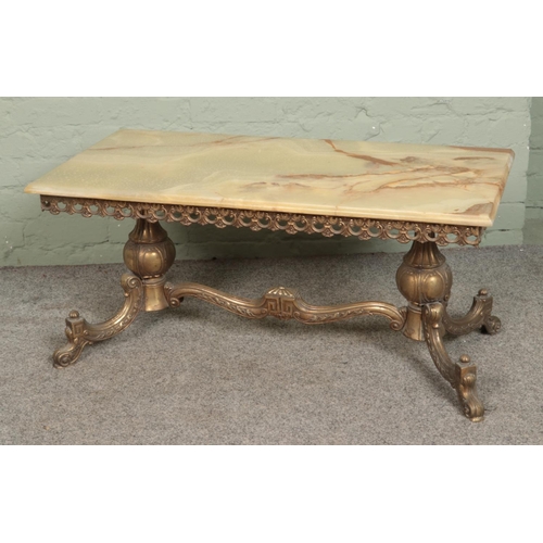 565 - A brass and onyx coffee table. Approx. dimensions 50cm x 100cm.