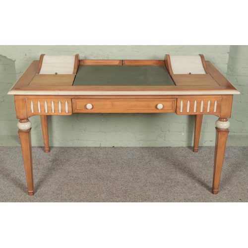 586 - A vintage pine desk featuring painted highlights with leather inset top flanked by tambour compartme... 