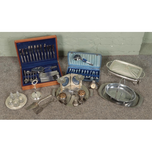 262 - A large collection of metalwares, to include boxed sets of flatware, swing handled basket, serving t... 