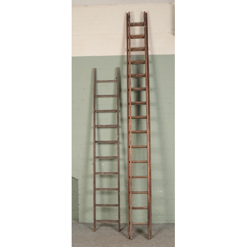 393 - A large set of wooden extension ladders and a single set of ladders