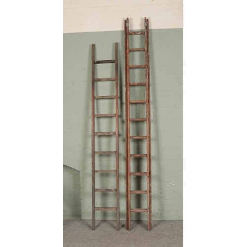 394 - A large set of wooden extension ladders and a single set of ladders