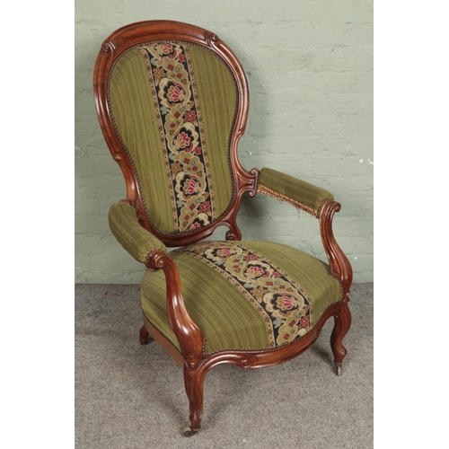 553 - A Victorian carved open armchair with tapestry style upholstery.