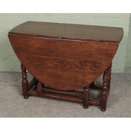 558 - A Georgian style oak drop leaf gate leg table.