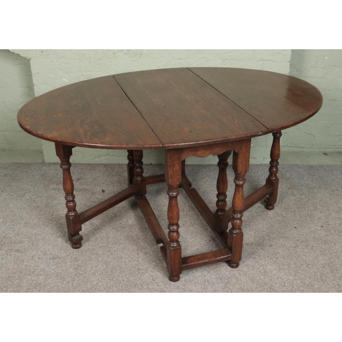 558 - A Georgian style oak drop leaf gate leg table.