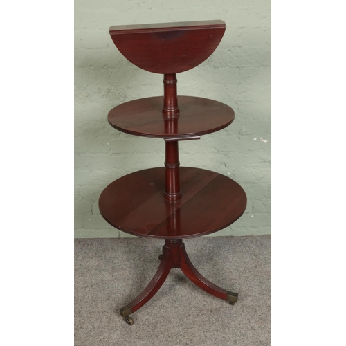 561 - A three tier mahogany dumb waiter featuring drop leaf to each tier.

Hx119cm