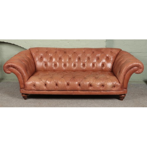 593 - A brown leather chesterfield type sofa raised on bun feet.

Length 250cm approx