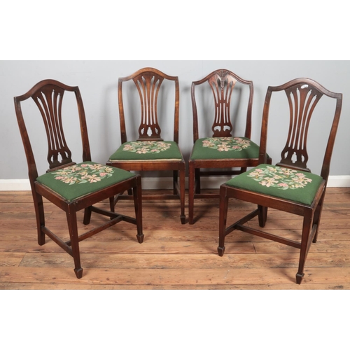 500 - A matched set of four mahogany dining chairs. Three with pierced slats, the other similar having car... 