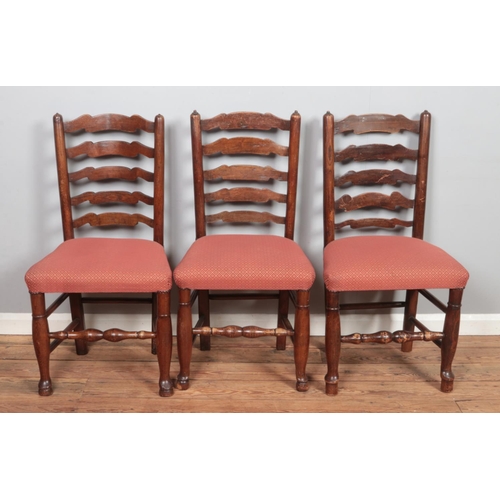 501 - A set of four ladder back dining chairs along with two similar carver examples.