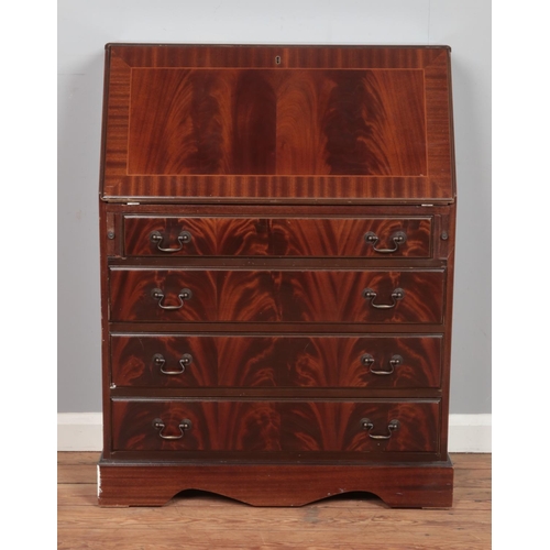 502 - A mahogany four drawer bureau, with drop down desk revealing partially fitted interior. Height: 101c... 