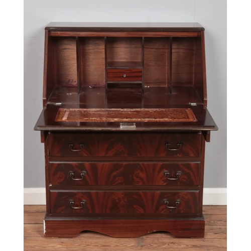 502 - A mahogany four drawer bureau, with drop down desk revealing partially fitted interior. Height: 101c... 