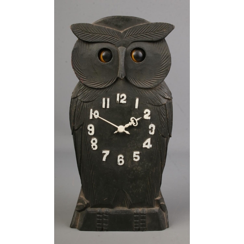 129 - A novelty carved owl Black Forest mantle clock with rocking eyes, 24cm tall.