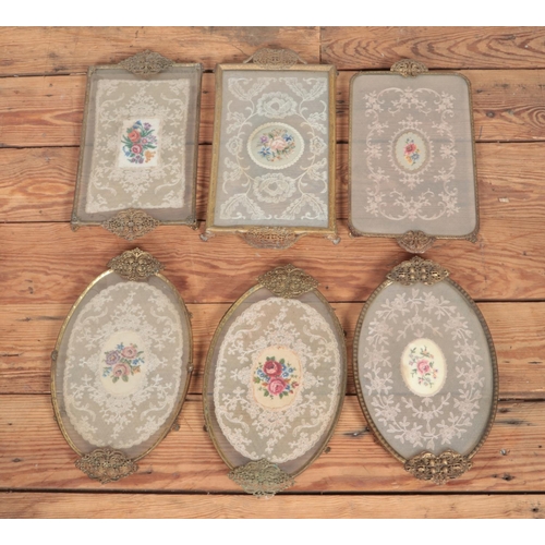 135 - A collection of six vanity trays with lace under glass with brass detail surround.